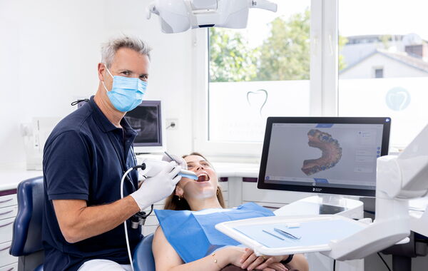 Zahnarzt Dr. Schlotthauer erstellt mit dem PrimeScan Intraoralscanner einen digitalen Zahnabdruck einer Patientin.
